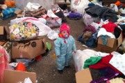 A child stands amid donated items for Uighur migrants in a tent in Kayseri, Turkey